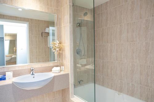 a bathroom with a sink and a glass shower at Great Southern Hotel Perth in Perth