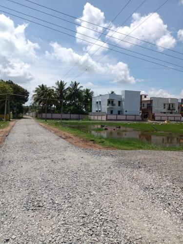 an empty dirt road with houses in the background at Doctor's Homestay in Tiruvannāmalai