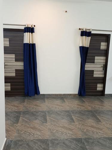 two blue curtains in a room with a tile floor at Doctor's Homestay in Tiruvannāmalai