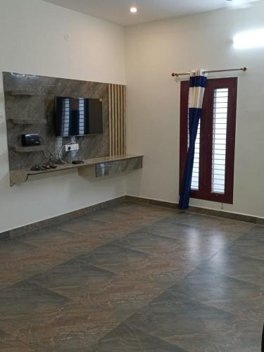 an empty room with a television on a wall at Doctor's Homestay in Tiruvannāmalai