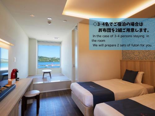 a hotel room with two beds and a desk and a window at Marea Resort Motobu in Motobu