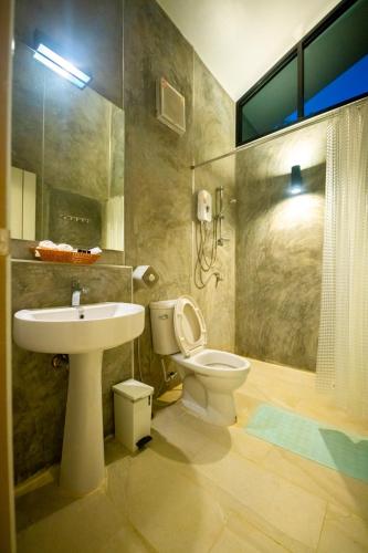 a bathroom with a toilet and a sink and a shower at สวนลุงวรRanongGlamping in Ban Bang Hin