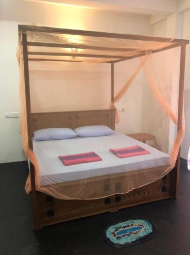 a bedroom with a canopy bed with two mats on it at SunRay Rest - Beach View Homestay in Mirissa