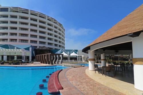 a hotel with a swimming pool and a building at Holiday Inn Tuxpan - Convention Center by IHG in Tuxpan de Rodríguez Cano