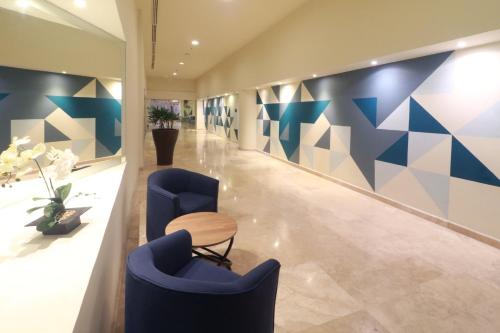 a lobby with two blue chairs and a table at Holiday Inn Tuxpan - Convention Center by IHG in Tuxpan de Rodríguez Cano