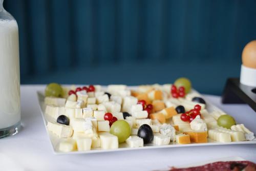 a plate of food with fruit on a table at Hotel Boutique Aquarel in Zalău