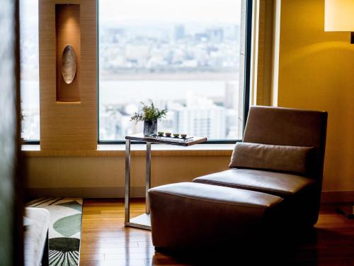 a chair sitting in front of a window with a view at InterContinental Hotel Osaka by IHG in Osaka