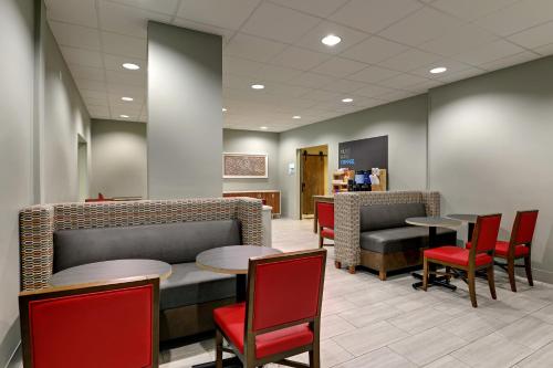 a waiting room with tables and red chairs at Holiday Inn Express Campbellsville by IHG in Campbellsville