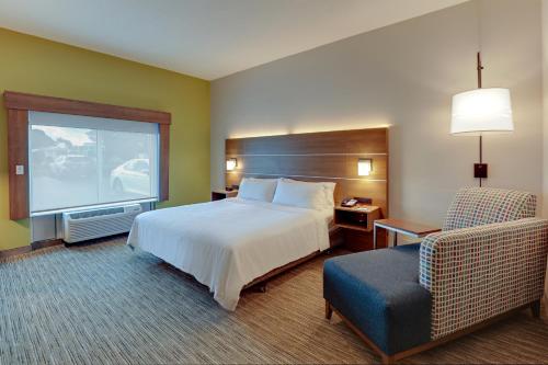Pokój hotelowy z łóżkiem i krzesłem w obiekcie Holiday Inn Express Campbellsville, an IHG Hotel w mieście Campbellsville