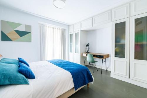 a white bedroom with a bed and a desk at Amazing flat 5 balconies in Chueca - Gran Via in Madrid