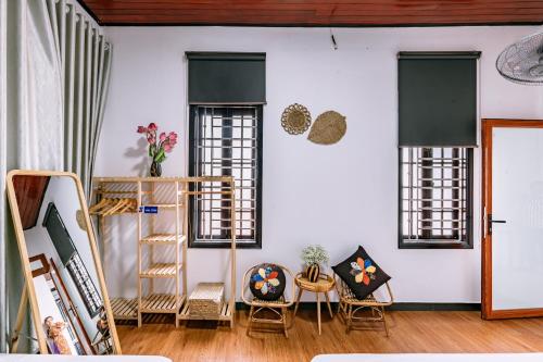 a room with windows and a ladder and chairs at Nana 2 Homestay in Hue