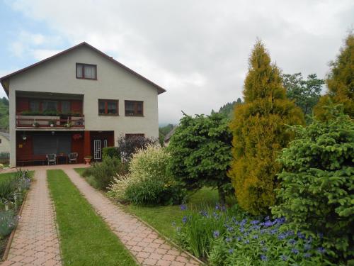 ein weißes Haus mit einem Garten davor in der Unterkunft Homestay Machom in Oščadnica