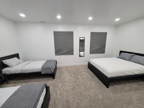 MapletonにあるSpacious & Modern Apartment, close to Universities and Mountainsの白い壁と窓が備わる客室で、ベッド2台が備わります。