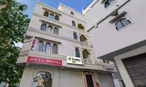 a white building with a sign in front of it at Treebo Trend Jheel Mahal in Udaipur