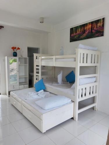 2 beliches brancos num quarto branco em RRJ's BEACH RESORT em Oslob