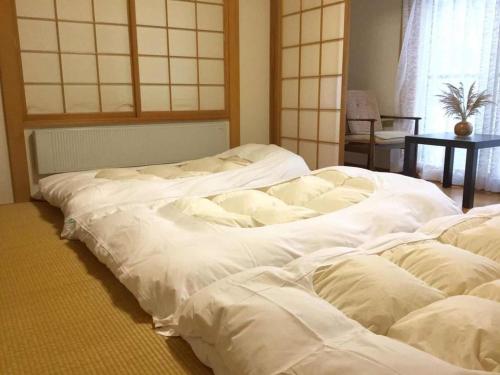 a group of white beds in a room at Second house TOYA / Vacation STAY 291 in Lake Toya