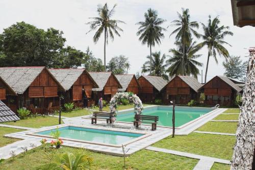 a resort with a pool and a row of houses at Nipoh Beach Cottage in Kijal