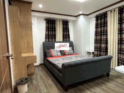 a bedroom with a black bed in a room at Ardeil's Baguio Transient in Baguio