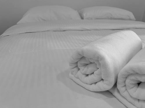 a black and white photo of an unmade bed at Aha Horizon Suites in Sepang