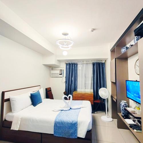 a hotel room with a bed and a television at eutz condominium daily rental in Cebu City