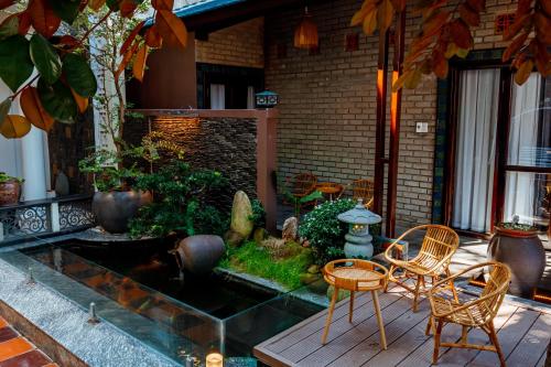a patio with chairs and a pond in a garden at Nana Homestay & Villa in Hue