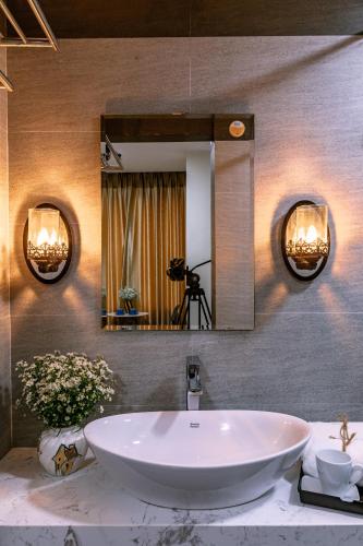 a bathroom with a large white tub and a mirror at Nana Homestay & Villa in Hue