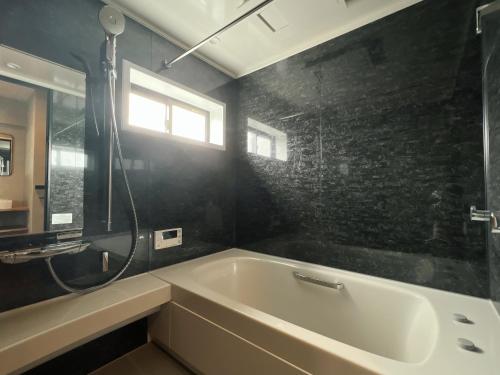 a bathroom with a bath tub and a window at ulu Tokyo in Tokyo