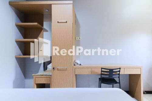 a bedroom with a desk and a chair next to a bed at Dea Homestay Syariah at Kertomenanggal Surabaya Mitra RedDoorz in Siwalapkerto