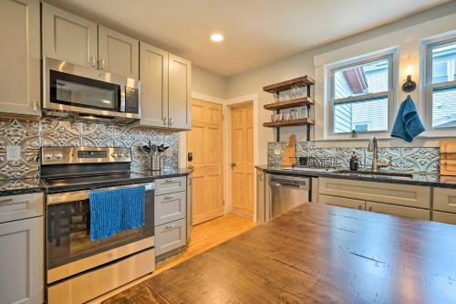 a large kitchen with stainless steel appliances and wooden floors at Updated Vintage Apartment Less Than half Mi to Main St in Keene