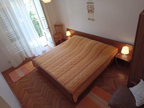 a large bed in a room with a window at Apartments Slavica - free WiFi in Vodice
