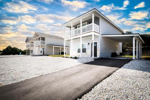 a white house with a driveway in front of it at Lakeshore Retreat in Canyon Lake