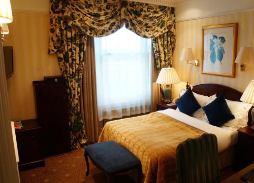a hotel room with a bed and a window at The Colonnade in London