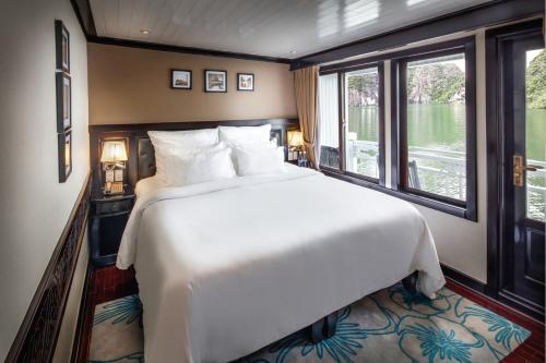 a large bed in a room with a large window at Paradise Luxury Sails Cruise in Ha Long