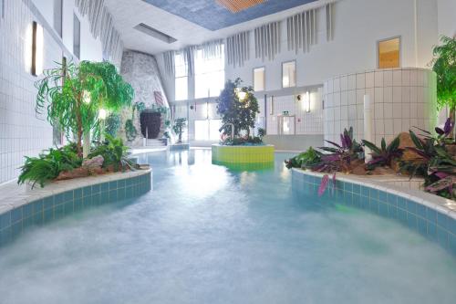 a large pool of water in a building at Lapland Hotels Luostotunturi & Amethyst Spa in Luosto