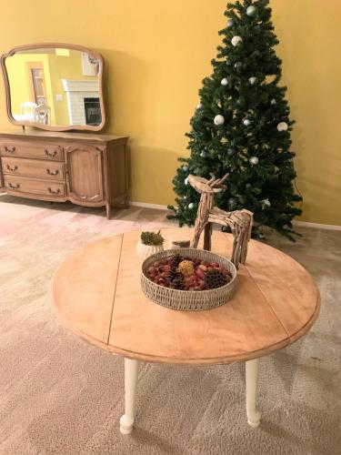 a table with a christmas tree in a living room at Wildflower Haven room in Hemet
