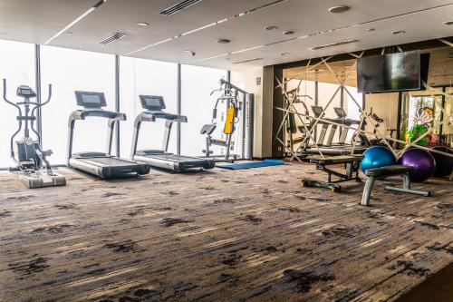 a gym with several treadmills and exercise machines at Queen Ann Nha Trang Hotel in Nha Trang