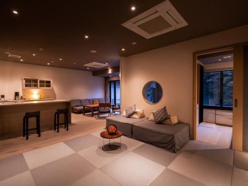 uma sala de estar com um sofá e um bar em Hakkei em Maniwa