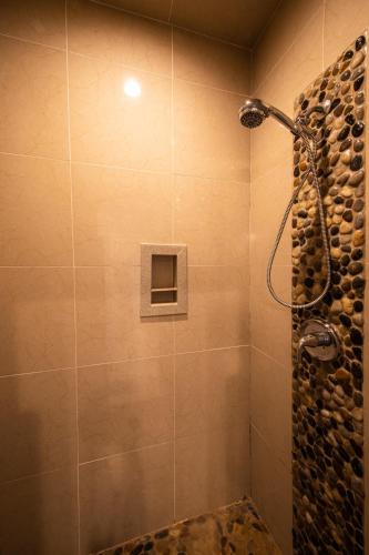a bathroom with a shower with a stone wall at Lakeview Luxury in Canyon Lake