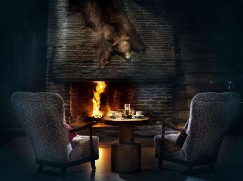 a dog jumping over a table in front of a fireplace at Lapland Hotels Luostotunturi & Amethyst Spa in Luosto