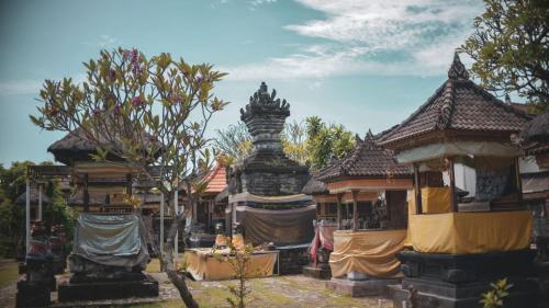 un gruppo di edifici con una statua al centro di PIMA Homestay a Pesanggaran