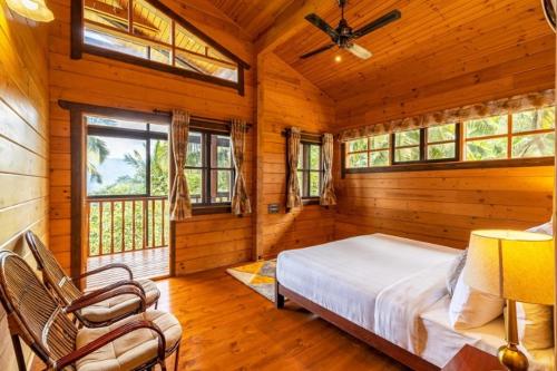 a bedroom with a bed in a wooden room with windows at amã Stays & Trails The Malabar Villa Heliconia, Kozhikode in Wayanad