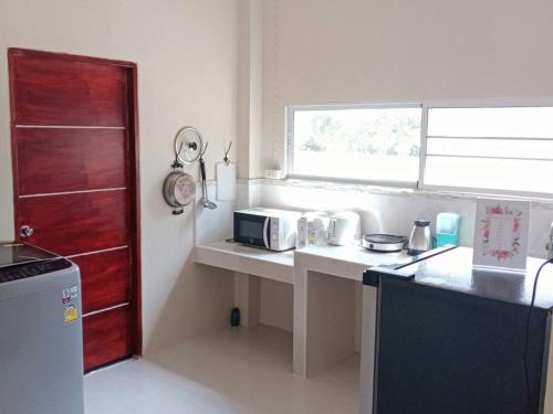 une cuisine avec un comptoir, un four micro-ondes et une fenêtre dans l'établissement W house Ranong 2bedroom villa 8/9, à Ranong