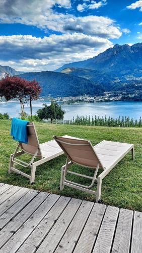 two chairs sitting on the grass next to a wooden deck at AGRITUR SEDICI - Bed and Breakfast in Tenna 