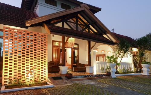 Ein Haus mit einer Terrasse und einem Haus in der Unterkunft Rumah Mertua Heritage in Yogyakarta