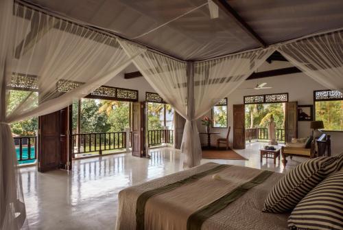 um quarto com uma cama grande num quarto com janelas em Mandalay em Ahangama