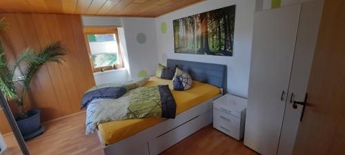 um quarto com uma cama num pequeno quarto em Ferienwohnung Seelust em Schluchsee