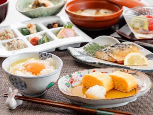 a table with plates of food and bowls of food at Hakkei in Maniwa