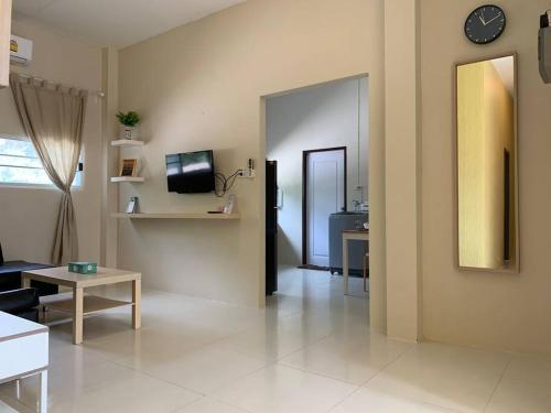 a living room with a couch and a clock on the wall at W House Ranong 2Bedroom villa 8/10 in Ban Lum Than