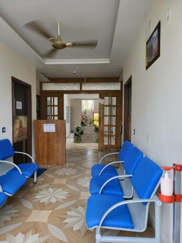 a waiting room at a hospital with blue chairs at Krishnabalram wellness & Ayurveda centre in Rishīkesh