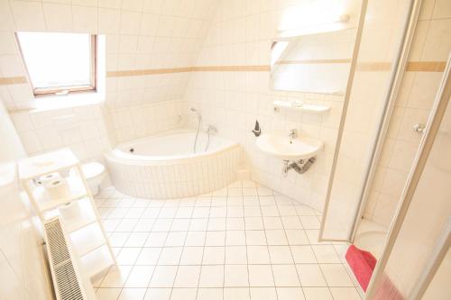 uma casa de banho branca com uma banheira e um lavatório em Hotel Namaste India em Piesteritz
